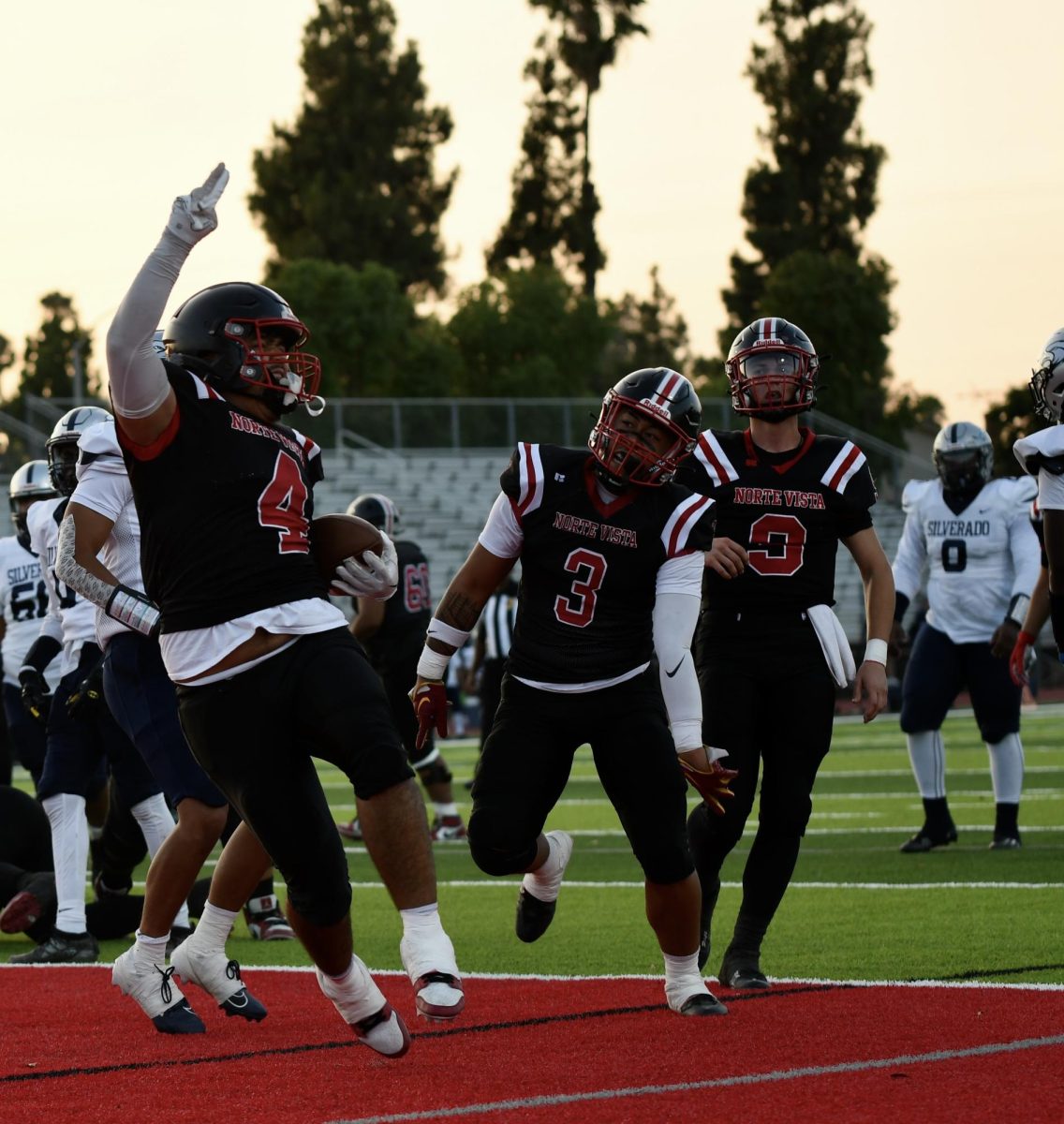 Senior Isaac Costello cheers while holding the ball at NOVIs first football game of the year on August 23, 2024.