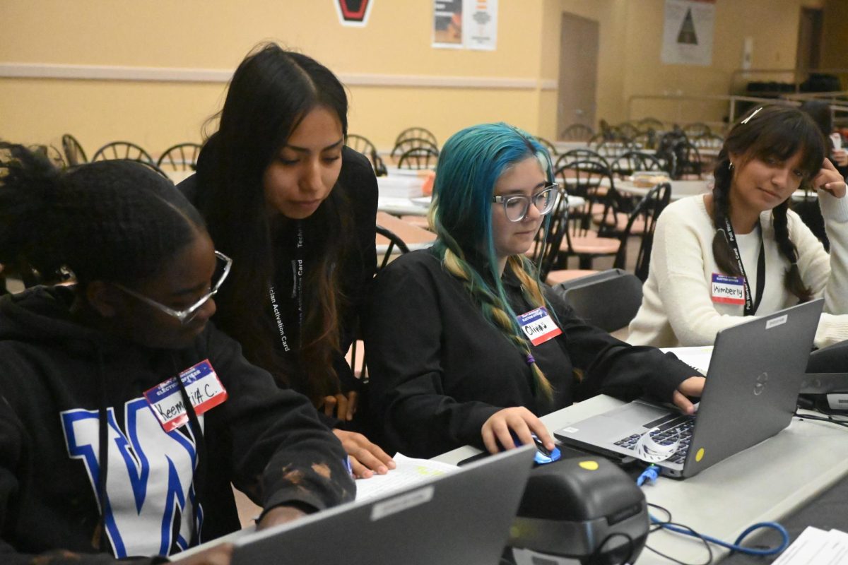 Students overview the current amount of votes between Trump and Kamala.