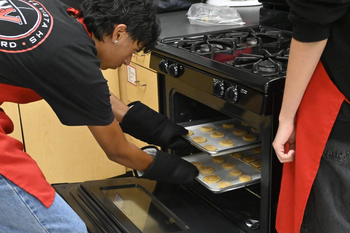 One of the students in food 1 placed some of the snickerdoodle dough in the oven to bake.
